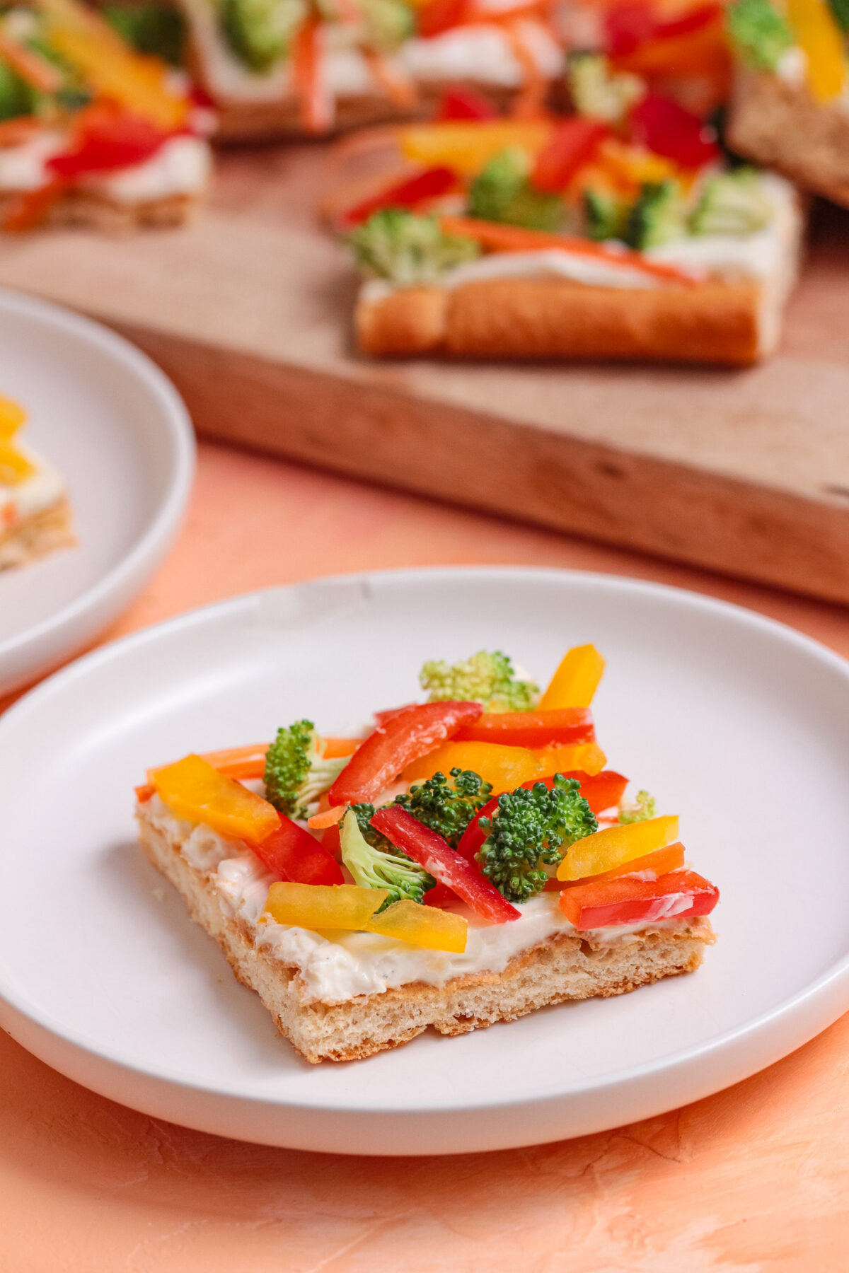 Easy cold veggie pizza with crescent roll crust, ranch cream cheese spread, broccoli, carrots, and bell peppers. Perfect for parties.